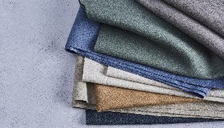 Katlanmış Camira Blazer Lite yün kumaş örnekleri, gri, yeşil, mavi ve bej doğal tonlarda
