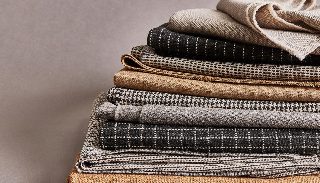 Camira Monochrome Sett kumaşının kazayağı, ekose, çizgi ve dama monokrom desenleri, siyah krem ve taba tonlarda katlı yığın halinde