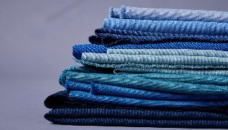 Katlanmış Camira Quest kumaş örnekleri, açık maviden lacivere farklı mavi tonlarında yığın halinde