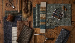 Camira ReSKU 2.0 kumaş örnekleri ahşap zeminde eski dokuma bobinleri, iplik çilesi, makas ve dokuma aletleriyle craft düzeninde