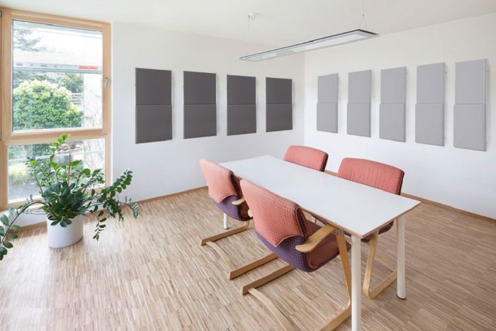 Toplantı odası duvarlarında gri kumaş kaplı akustik panel uygulaması, yankı ve yansıma kontrolü