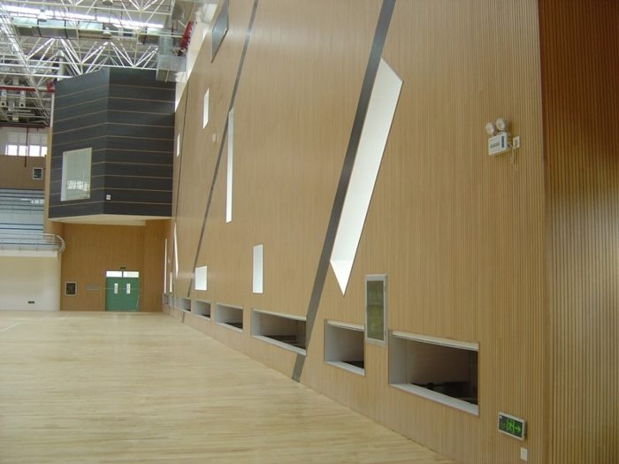Spor salonu duvarında açık meşe tonlu çıtalı ahşap akustik panel uygulaması