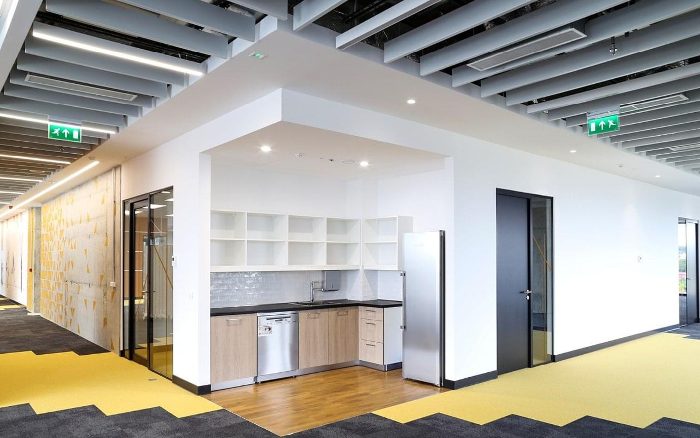 Ofis koridor tavanına monte edilmiş gri akustik baffle panel sırası