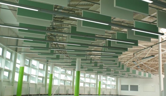 Spor salonu tavanına kademeli monte edilmiş yeşil ve beyaz akustik baffle paneller