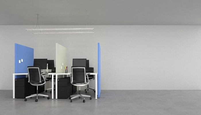Ofis masalarını bölen mavi ve krem akustik paravanlarla oluşturulmuş dört kişilik çalışma alanı