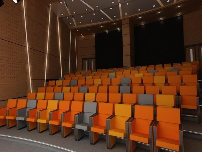 Delikli ahşap panel kaplı duvar ve tavana sahip turuncu koltuklu konferans salonu görseli