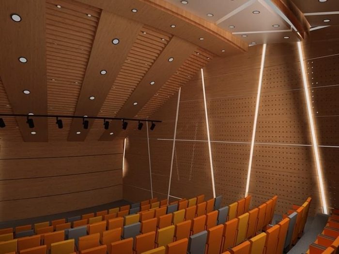 Delikli ahşap panel duvarlı ve spot aydınlatmalı turuncu koltuklu sinema salonu görseli