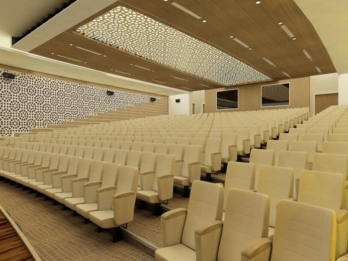 CNC kesim kafesli tavan ve delikli ahşap duvarlı krem koltuklu konferans salonu görseli