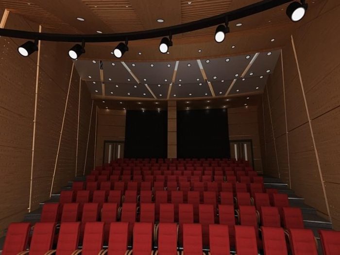 Delikli ahşap panel duvarlı ve koyu aydınlatmalı tavanlı kırmızı koltuklu oditoryum görseli
