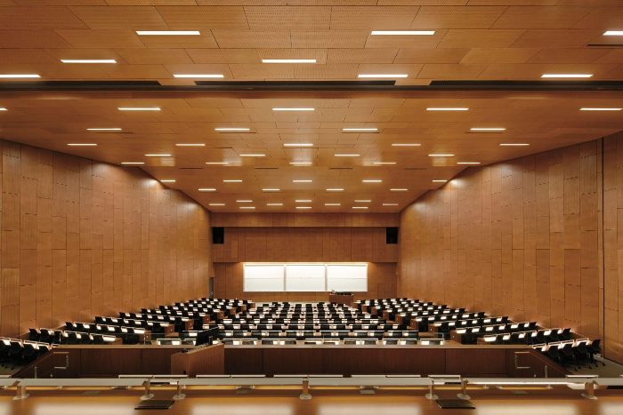 Delikli ahşap panel kaplı tavan ve duvarlara sahip kademeli büyük amfi salonu