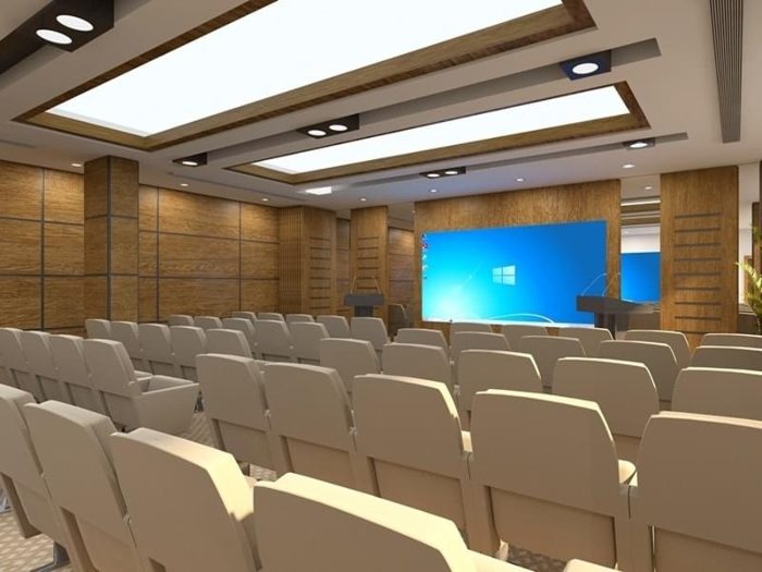 Toplantı salonu renderı, ahşap derzli akustik duvar panelleri, ekran ve krem koltuk sıraları