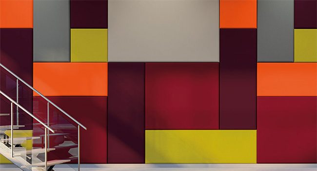 Merdiven boşluğu duvarında turuncu bordo sarı kumaş kaplı akustik panel kompozisyonu