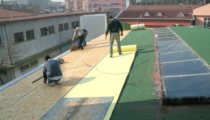 Çatıda OSB yüzeyine akustik EVA şilte seren uygulama ekibi ve yeşil çatı örtüsü