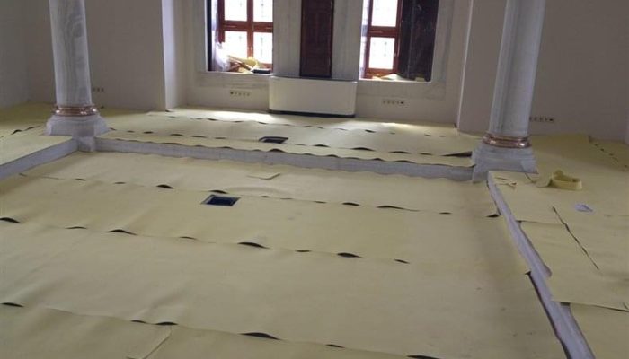 Sütunlu geniş salonun zeminine ek yerleri örtüşecek biçimde serilmiş akustik EVA şilte