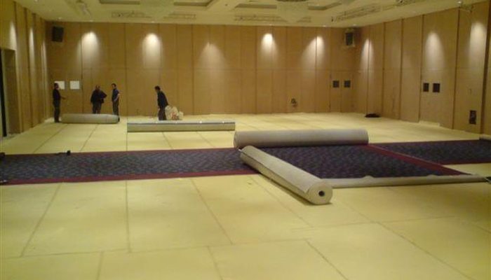 Konferans salonunda şilte kaplı zemine halı serimi