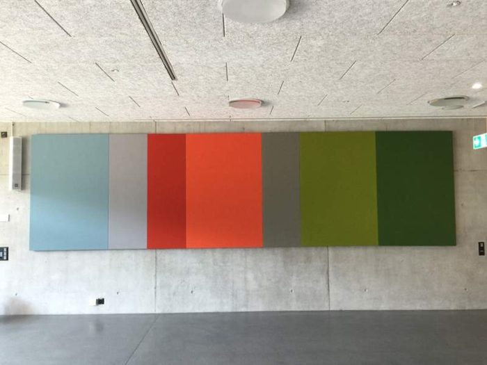 Çok renkli akustik duvar panelleri, beton duvarda geniş yatay yerleşim uygulaması