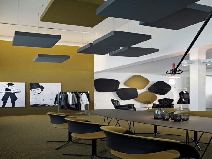 Gri asılı tavan baffle'ları, hardal duvar, showroom ve toplantı masası uygulaması