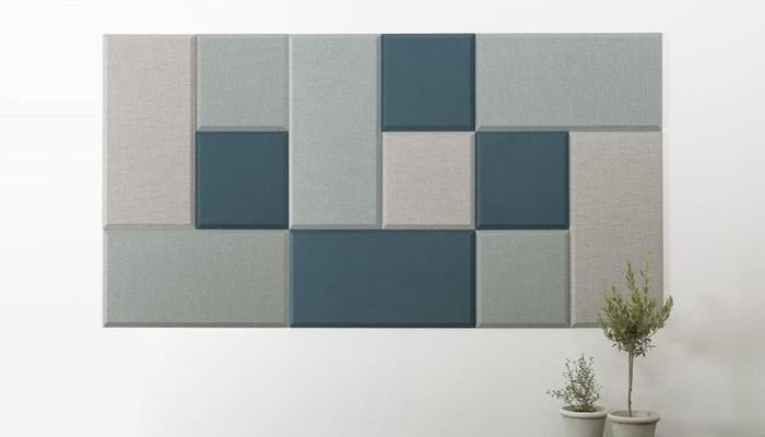 Yeşil ve gri tonlarında farklı derinlikte kare akustik kumaş panellerle oluşturulan duvar kompozisyonu