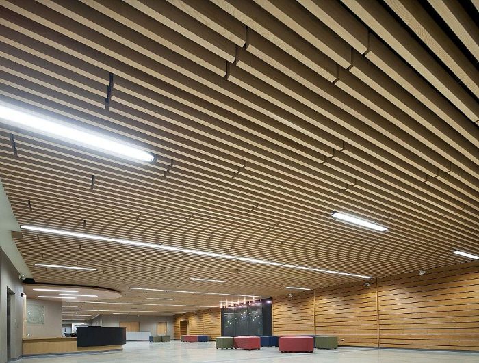 Geniş fuaye alanında naturel ahşap akustik linear tavan ve lineer aydınlatma