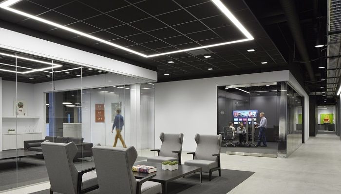 Ofis bekleme alanında siyah akustik asma tavan ve lineer LED aydınlatma
