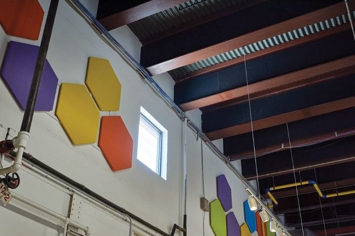 Duvarda mor, sarı ve yeşil altıgen akustik panel kompozisyonu