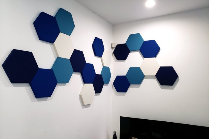 Duvarda mavi tonlarında altıgen akustik panel kompozisyonu