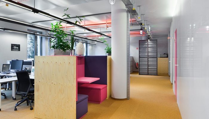 Ahşap bölmeler ve renkli oturma nişleriyle düzenlenmiş açık ofis