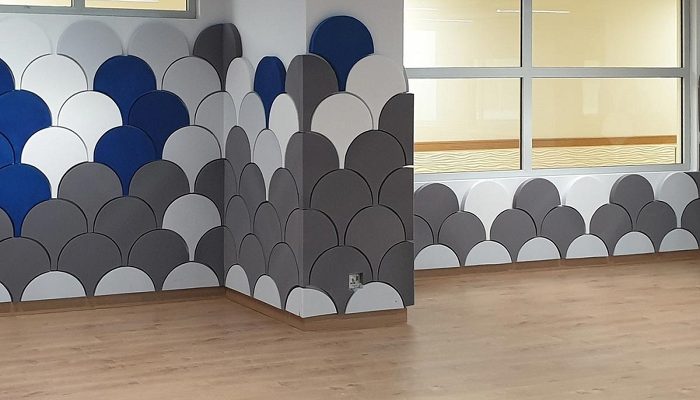 Geniş ofis duvarında pul desenli akustik panel bandı