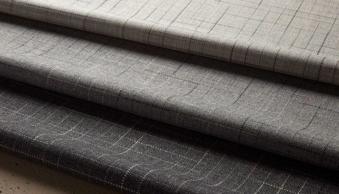 Camira Kyoto kumaşının krem, gri ve antrasit tonlarında ince ızgara desenli katmanlı kıvrımları