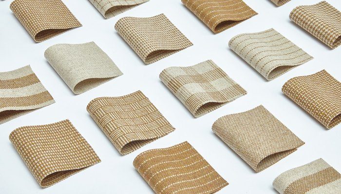 Camira Monochrome Sett II yün ve keten kumaşının dama, dalga, hasır ve çizgi desenli örnekleri, sıcak taba ve krem tonlarda beyaz zeminde ızgara düzeninde