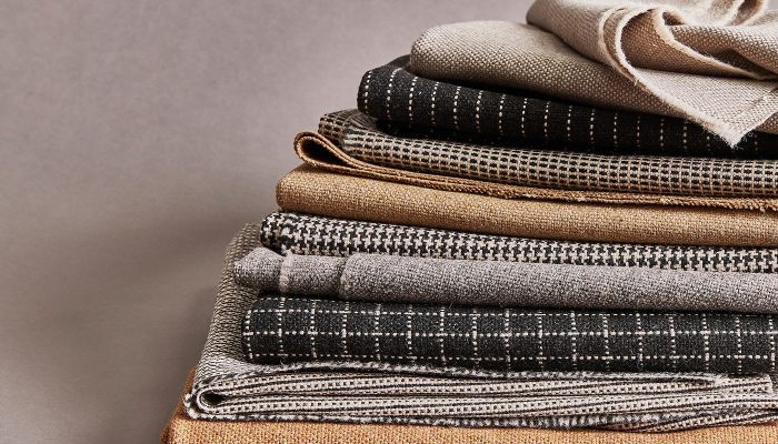 Camira Monochrome Sett kumaşının kazayağı, ekose, çizgi ve dama monokrom desenleri, siyah krem ve taba tonlarda katlı yığın halinde