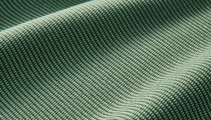 Camira Oceanic geri dönüştürülmüş polyester kumaşının deniz yeşili çift tonlu dimi dokusunun yakın çekimi