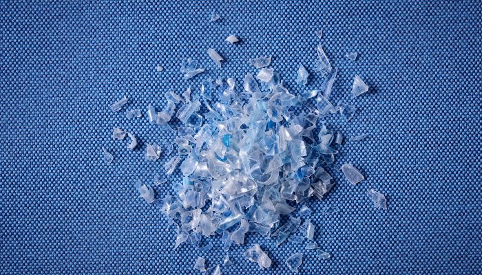 Camira Quest'in ham maddesi olan geri dönüştürülmüş PET plastik parçacıkları, mavi Quest kumaşı üzerinde