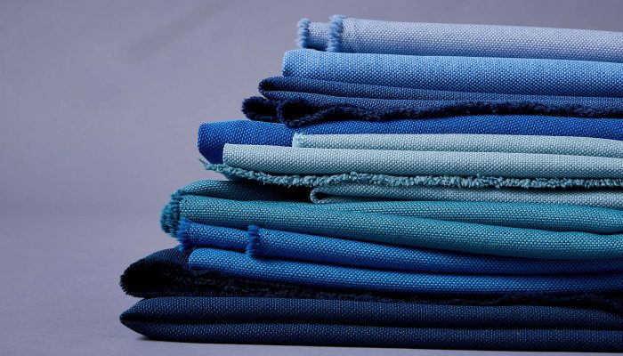 Katlanmış Camira Quest kumaş örnekleri, açık maviden lacivere farklı mavi tonlarında yığın halinde