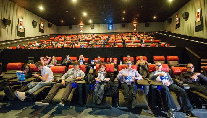 Seyircilerle dolu sinema salonunda kademeli koltuk sıraları