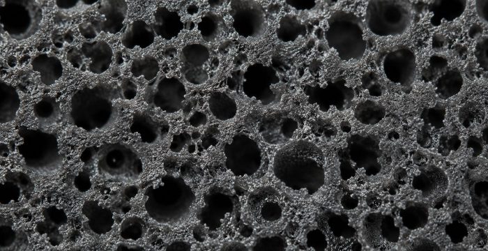 Titreşim yalıtım elastomerinin karışık hücreli gözenekli yüzeyi, makro çekimde koyu gri açık gözenek dokusu