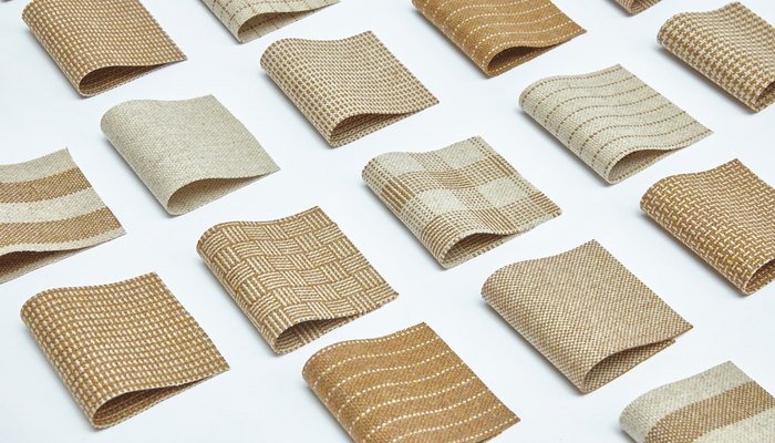Camira Monochrome Sett II yün ve keten kumaşının dama, dalga, hasır ve çizgi desenli örnekleri, sıcak taba ve krem tonlarda beyaz zeminde ızgara düzeninde